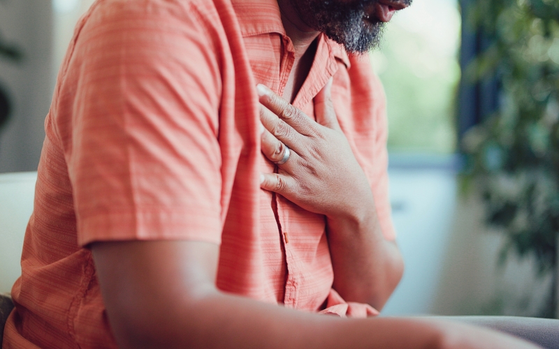 Focus su uomo di mezza età mentre si tocca il petto come se stesse respirando a fatica